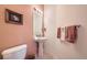 Neat powder room featuring a pedestal sink, decorative mirror, and soft lighting at 4143 Da Vinci Dr, Longmont, CO 80503