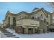 Two-story townhouse with charming balcony and front entrance, creating a welcoming and inviting curb appeal in a snow-covered setting at 4143 Da Vinci Dr, Longmont, CO 80503