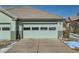 A two-car garage with a well-kept exterior, showing snowy landscaping at 4143 Da Vinci Dr, Longmont, CO 80503