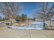 A picturesque park featuring a snow-covered ground, mature trees, and recreational space at 4143 Da Vinci Dr, Longmont, CO 80503