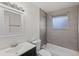 Clean bathroom with gray tile, a tub, and updated vanity at 12516 E Alaska Ave, Aurora, CO 80012