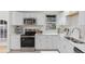 Modern kitchen featuring white cabinets, stainless steel appliances, and a tile backsplash at 12516 E Alaska Ave, Aurora, CO 80012