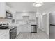 Renovated kitchen featuring white cabinets, stainless steel appliances, and tile backsplash at 12516 E Alaska Ave, Aurora, CO 80012