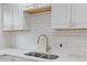 Modern kitchen sink with gold faucet and white tile backsplash at 12516 E Alaska Ave, Aurora, CO 80012