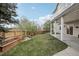 Spacious backyard with lush green grass, wooden fence, concrete patio, and mature trees at 423 N Snowmass Cir, Superior, CO 80027