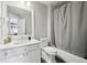 Cozy bathroom featuring a white vanity with mirror, toilet, and a tub/shower combination with a gray curtain at 423 N Snowmass Cir, Superior, CO 80027