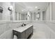 A stylish bathroom featuring striped walls, marble accents, double vanity, and modern fixtures, blending sophistication with comfort at 423 N Snowmass Cir, Superior, CO 80027