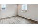 Bright bedroom with wood-look flooring and a large window offering natural light at 14441 Clover Dr, Mead, CO 80504