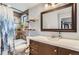 Bathroom features wood-look tile shower, floating shelves, and a wood vanity with white countertop at 1740 Shavano St, Longmont, CO 80504