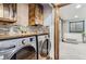 Well-appointed laundry room featuring modern washer and dryer, custom cabinets, and stylish tile backsplash at 1740 Shavano St, Longmont, CO 80504