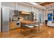 Modern kitchen featuring a large island with seating, stainless steel appliances, and hardwood floors at 2955 Inca St # 2F, Denver, CO 80202