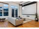 Bright living room with large windows, wood floors, and a projector screen for entertainment at 2955 Inca St # 2F, Denver, CO 80202