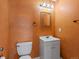 Bathroom featuring bronze walls, vanity, mirror and a toilet at 3853 S Malta St, Aurora, CO 80013