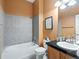 Cozy bathroom features a shower over the tub, grey tiling, and sink with vanity at 3853 S Malta St, Aurora, CO 80013