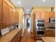 Spacious kitchen with stainless steel appliances, granite countertops, tile flooring, and wooden cabinetry at 3853 S Malta St, Aurora, CO 80013