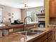 View of a kitchen bar with stainless steel sink, granite countertop, and open living area with a fireplace at 3853 S Malta St, Aurora, CO 80013