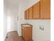 Laundry room with tile flooring, sink, wooden cabinets and a door to the exterior at 3853 S Malta St, Aurora, CO 80013
