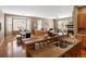 Open-concept living space with hardwood floors, fireplace, and an adjacent dining area with large windows at 3853 S Malta St, Aurora, CO 80013
