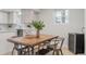 Bright dining area features a natural wood table with metal chairs, plus a wine cooler at 1645 Wabash St, Denver, CO 80220