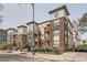 Multi-story brick condo building featuring balconies and manicured landscaping on a tree-lined street at 1727 N Pearl St # 107, Denver, CO 80203