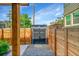 Fenced backyard with modern, gray storage shed and gravel, accessed via a wooden gate at 2143 S Acoma St, Denver, CO 80223