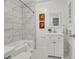 Bright bathroom with marble tiled shower and classic black and white tile flooring at 2143 S Acoma St, Denver, CO 80223