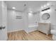 Bright bathroom features a shower-tub combo with white marble tile and a wood-look vanity at 2143 S Acoma St, Denver, CO 80223