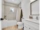 Well-lit bathroom includes a shower-tub combo, patterned tile, white cabinets, and a neutral color palette at 2143 S Acoma St, Denver, CO 80223