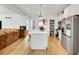 Open kitchen with island, white cabinets, and stainless-steel appliances flows into the living area at 2143 S Acoma St, Denver, CO 80223