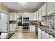 Modern kitchen with stainless steel appliances, sleek countertops, and ample white cabinetry at 2143 S Acoma St, Denver, CO 80223