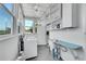 Bright laundry room with a vintage wash sink and shelving for ample storage at 2143 S Acoma St, Denver, CO 80223