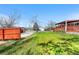 Expansive backyard featuring lush green grass, a covered patio, and a detached garage at 2698 Fern Dr, Westminster, CO 80030