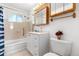 Bathroom featuring a white vanity and toilet, shower-tub combination, and natural lighting at 2698 Fern Dr, Westminster, CO 80030