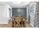 Inviting dining room featuring a rustic table, gray accent wall, and natural light from a window at 2698 Fern Dr, Westminster, CO 80030