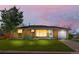 Charming brick home with a lush green lawn and mature tree under a colorful dusk sky at 2698 Fern Dr, Westminster, CO 80030