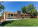 Spacious backyard featuring a well-maintained lawn, brick chimney, and concrete patio, perfect for outdoor enjoyment at 8228 Marshall Ct, Arvada, CO 80003
