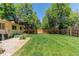 Expansive backyard showcasing a lush lawn, mature trees, privacy fence, and gravel accent at 8228 Marshall Ct, Arvada, CO 80003