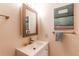 Bright bathroom features a modern vanity, mirror, and artistic decor at 8228 Marshall Ct, Arvada, CO 80003
