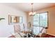 Well-lit dining room featuring a modern glass table, upholstered chairs, and bright window at 8228 Marshall Ct, Arvada, CO 80003