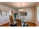 Bright dining room featuring glass table, upholstered chairs, modern chandelier, and decor at 8228 Marshall Ct, Arvada, CO 80003