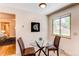 Cozy eat-in kitchen area features a round glass table and woven chairs by a window at 8228 Marshall Ct, Arvada, CO 80003