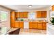 Spacious kitchen featuring wood cabinets, white appliances, and view to the eat-in area at 8228 Marshall Ct, Arvada, CO 80003