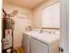 Practical laundry room equipped with a washer, dryer, and water heater at 8228 Marshall Ct, Arvada, CO 80003