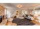 Open living area featuring brick fireplace, play area, modern sofa, and open kitchen access at 8228 Marshall Ct, Arvada, CO 80003