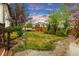 Well-manicured backyard with green grass, stone walkways, and lush landscaping creating a private outdoor oasis at 6334 Empire Ave, Frederick, CO 80516