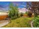 Grassy backyard featuring a lush lawn, mature trees, and charming brick walkways enhancing the outdoor ambiance at 6334 Empire Ave, Frederick, CO 80516
