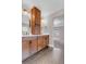 Bathroom with double sink vanity, wood cabinets, and view into bonus living room at 6334 Empire Ave, Frederick, CO 80516