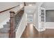 Bright foyer featuring wood floors, staircase with iron balusters, and adjacent study with glass french doors at 6334 Empire Ave, Frederick, CO 80516