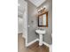Modern powder room featuring a pedestal sink, decorative mirror, and stylish lighting fixtures, creating a functional space at 6334 Empire Ave, Frederick, CO 80516