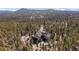 An aerial view showing the house nestled in a serene forest setting at 11421 Belle Meade Dr, Conifer, CO 80433